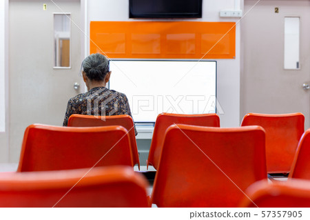 Old woman sit on orange chair waiting for health services in the hospital. 57357905