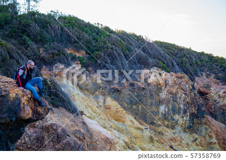 A man in a high place, on a rock, committing suicide, he will jump down A man in a high place, on a rock, committing suicide, he will jump down 57358769