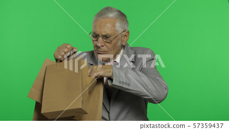 Elderly businessman with shopping bags. Old man in formal wear after shopping Elderly businessman with shopping bags. Old man in formal wear after shopping 57359437