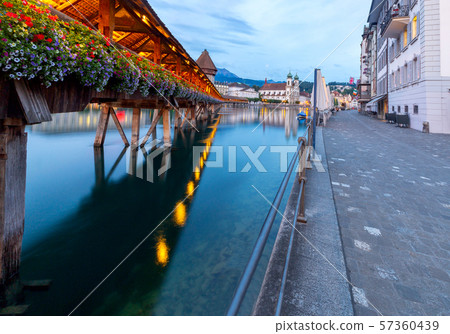 Lucerne. The famous Chapel, Kapellbrucke bridge at dawn in night lighting. 57360439