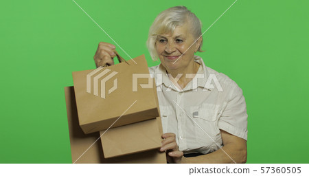 An elderly woman with shopping bags. Shopping. Presents. Chroma key An elderly woman with shopping bags. Shopping. Presents. Chroma key 57360505