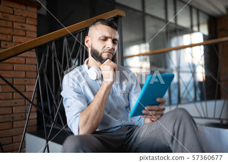Businessman reading e-mail and feeling thoughtful Businessman reading e-mail and feeling thoughtful 57360677