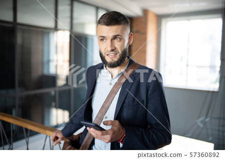 Businessman feeling thoughtful after reading message Businessman feeling thoughtful after reading message 57360892