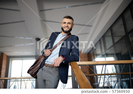 Beaming office worker wearing smart watch standing near stairs Beaming office worker wearing smart watch standing near stairs 57360930