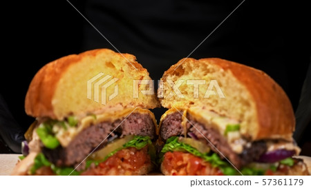 Cut craft burger is cooking on black background. Consist sauce salsa, lettuce, red onion, pickle Cut craft burger is cooking on black background. Consist sauce salsa, lettuce, red onion, pickle 57361179