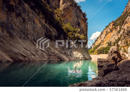 Man jumping into the water of a gorge in the Pyrenees mountains 57361806