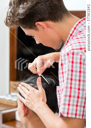 Barber combing the customer's hair 57361841