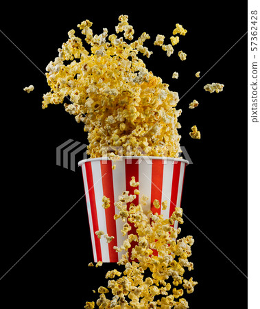 Flying popcorn from striped bucket isolated on black background Flying popcorn from striped bucket isolated on black background 57362428
