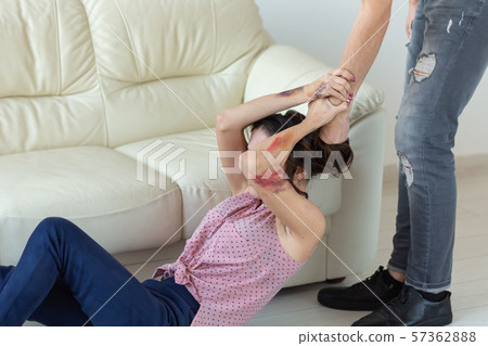 domestic violence, victim and abuse concept - cruel aggressive man grabbing woman lying on the floor 57362888