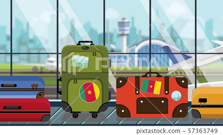 Suitcases with Cameroonian flag stickers on baggage carousel in airport, close-up. Travel to Suitcases with Cameroonian flag stickers on baggage carousel in airport, close-up. Travel to 57363749