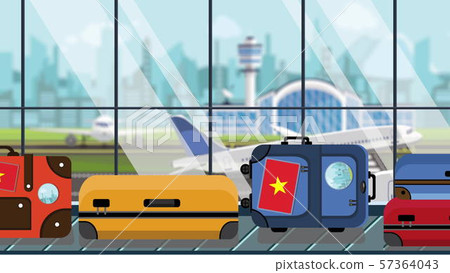 Suitcases with Vietnamese flag stickers on baggage carousel in airport, close-up. Tourism in Vietnam 57364043