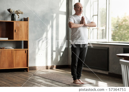 Hispanic man working out, yoga in basic standing asana tadasana Hispanic man working out, yoga in basic standing asana tadasana 57364751
