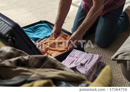 Senior man hands packing clothes in suitcase. Senior man hands packing clothes in suitcase. 57364759