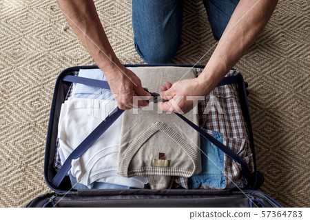 Senior man hands packing clothes in suitcase. Senior man hands packing clothes in suitcase. 57364783