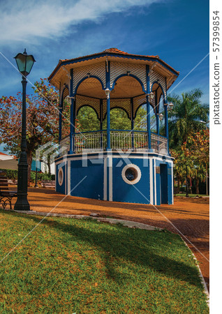 Old colorful gazebo and lighting pole in a green garden Old colorful gazebo and lighting pole in a green garden 57399854