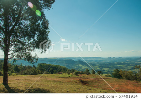 Meadows and trees in a green valley with hilly landscape Meadows and trees in a green valley with hilly landscape 57401914