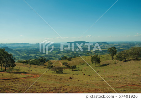 Meadows and trees in a green valley with hilly landscape Meadows and trees in a green valley with hilly landscape 57401926