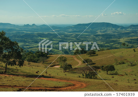 Meadows and trees in a green valley with hilly landscape Meadows and trees in a green valley with hilly landscape 57401939