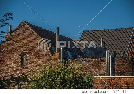 Brick building, roofs and chimneys at sunset in Tielt 57414161