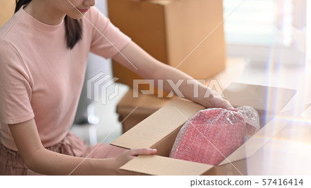 Cropped shot online small business owner packing drop product on box. 57416414