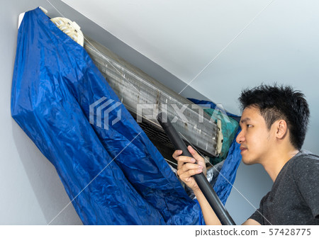 man using vacuum cleaner to cleaning air man using vacuum cleaner to cleaning air 57428775