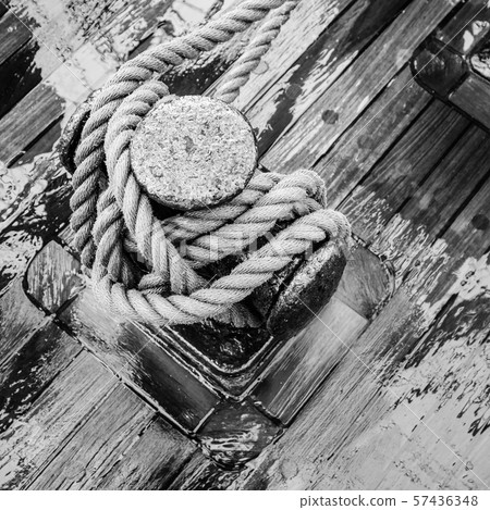 Bollard with a rope on the wooden deck of a 57436348