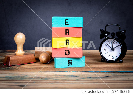 Error concept. Stamps and clock on the office table and colorful wooden blocks with text 57436836