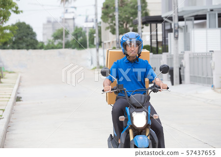 Courier delivering parcel box by motorcycle 57437655