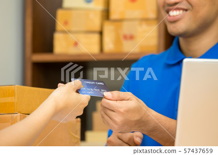 Hand of woman paying by credit card for parcels Hand of woman paying by credit card for parcels 57437659