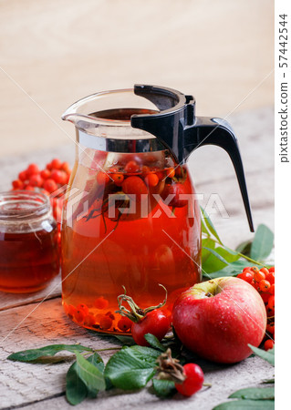 Hot warming drink in glass teapot and honey in jar 57442544