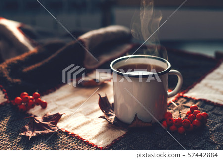 Autumn hot steaming cup of coffee or tea. 57442884