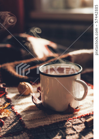 Autumn hot steaming cup of coffee or tea. 57442885