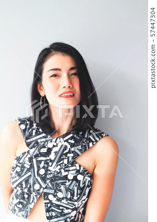 Black hair Asian woman smiling looking to camera. 57447304
