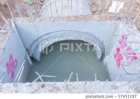 Concrete Drainage Pipe on a Construction Site, Concrete drainage tank on construction site, construction site at the road Concrete Drainage Pipe on a Construction Site, Concrete drainage tank on construction site, construction site at the road 57451197