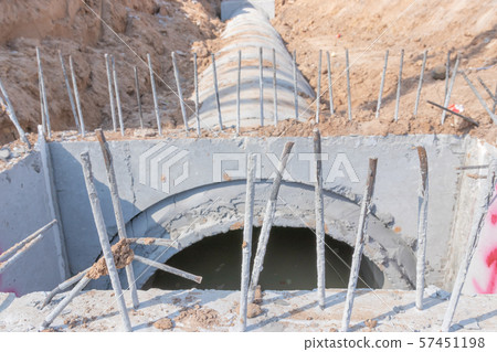 Concrete Drainage Pipe on a Construction Site, Concrete drainage tank on construction site, construction site at the road Concrete Drainage Pipe on a Construction Site, Concrete drainage tank on construction site, construction site at the road 57451198