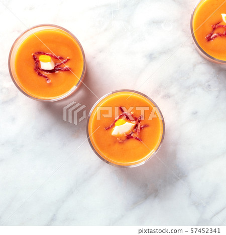 Salmorejo, Spanish cold tomato and bread soup, in glasses on a marble background, overhead square Salmorejo, Spanish cold tomato and bread soup, in glasses on a marble background, overhead square 57452341