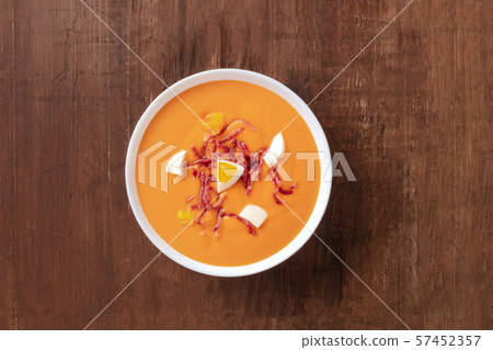 Salmorejo, Spanish cold tomato soup, shot from the top on a dark rustic wooden background with a 57452357