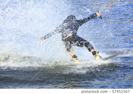 Wakeboarder rushing through the water at high 57452567