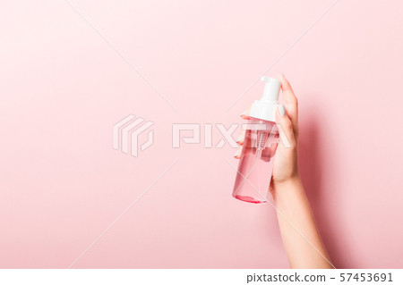 Female hand holding spray cream bottle of lotion Female hand holding spray cream bottle of lotion 57453691