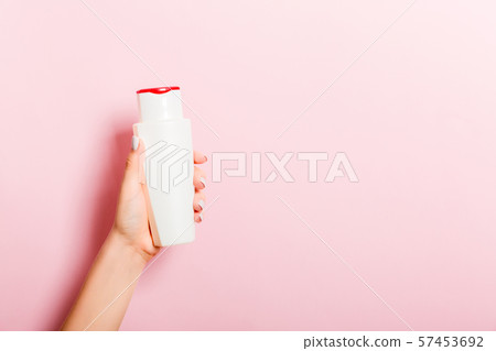 Female hand holding cream bottle of lotion 57453692