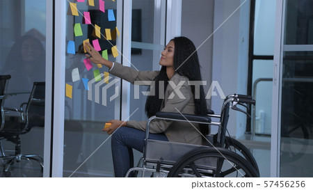 Business concepts. The disabled girl is writing an Business concepts. The disabled girl is writing an 57456256