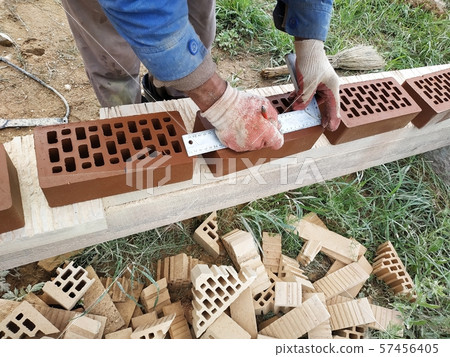 The worker translates the facade bricks for The worker translates the facade bricks for 57456405