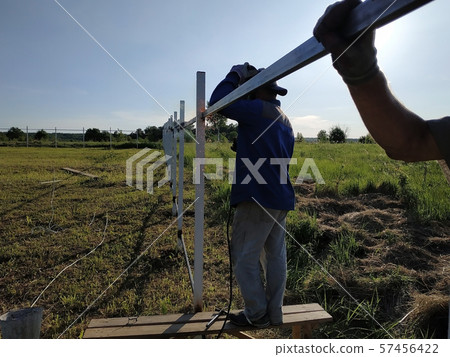 Worker in protective mask welds steel handrails 57456422