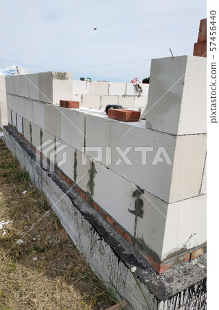 Laying the wall of gas blocks with tools and glue. 57456440