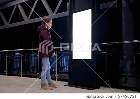 Woman looking at blank white display kiosk at exhibition - white screen concept Woman looking at blank white display kiosk at exhibition - white screen concept 57456751