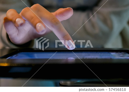 Woman hand using touchscreen display of floor standing black tablet kiosk Woman hand using touchscreen display of floor standing black tablet kiosk 57456818