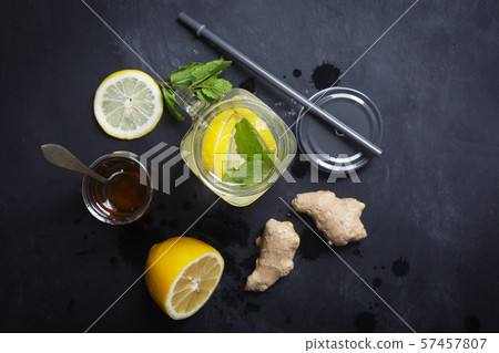Ginger Water in Glass jar With Lemon and Honey on a Black Background, Top View Ginger Water in Glass jar With Lemon and Honey on a Black Background, Top View 57457807