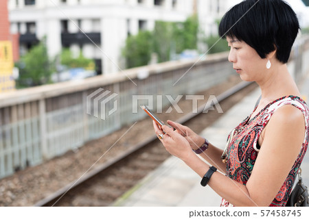 mature traveling woman waiting and using a mature traveling woman waiting and using a 57458745