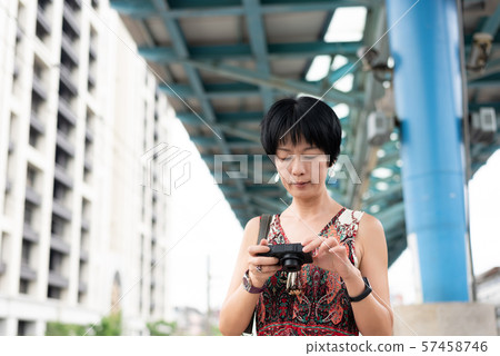 mature Asian woman using digital camera 57458746