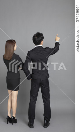 rear view of young business man and woman pointing rear view of young business man and woman pointing 57459944